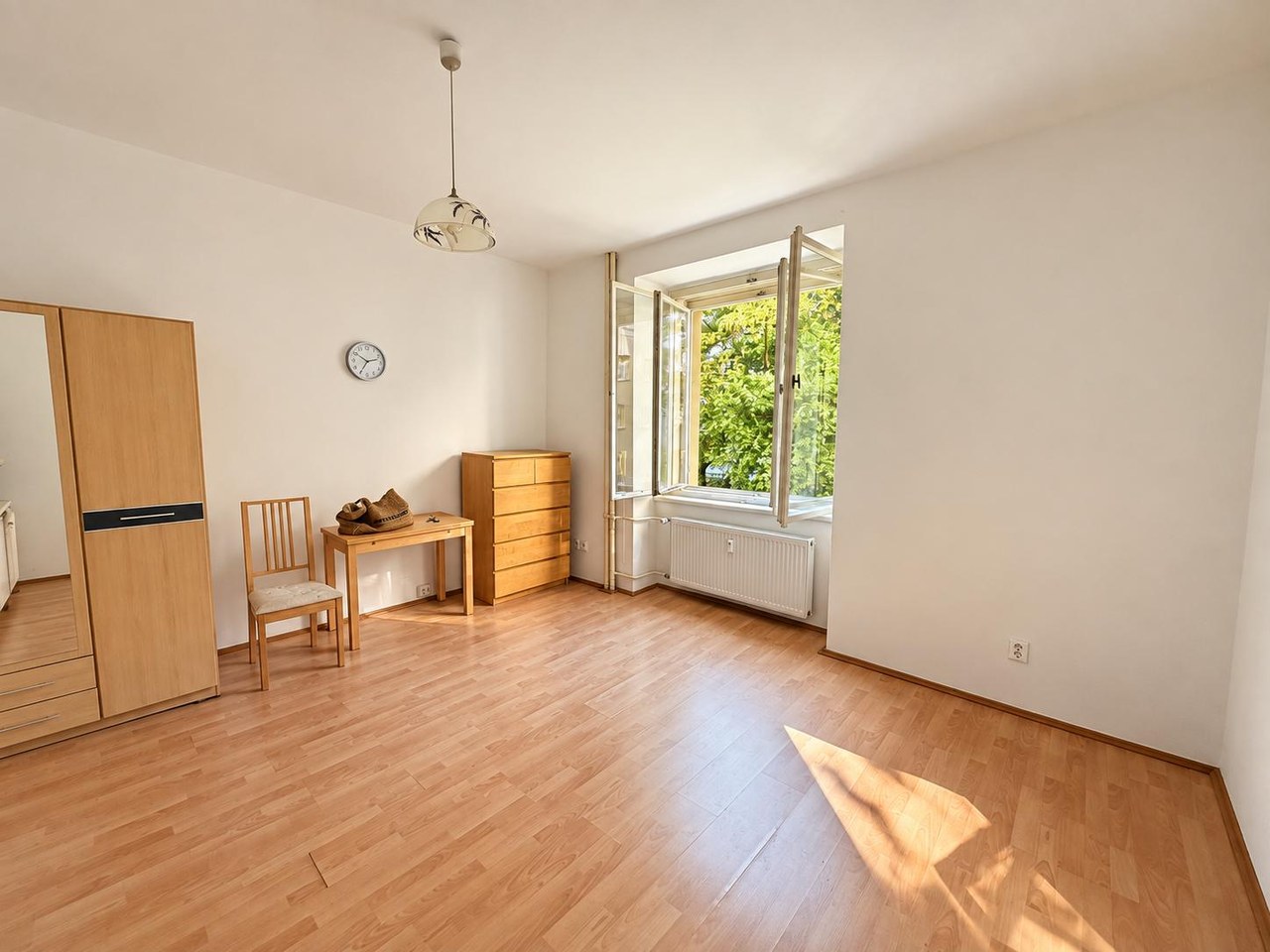 Obytný pokoj s oknem do zeleného vnitrobloku